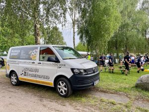 VW Transporter auf MSR Verpflegungsstation mit pausierenden Radlern im Hintergrund